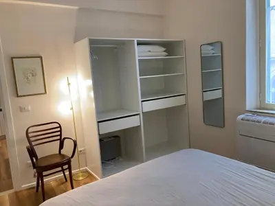 a bedroom with a bed and a chair and shelves at Casa MANÍ Campo de Fiori in Rome