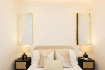 a bedroom with two mirrors above a bed with pillows at Colosseum Boutique Apartment in Rome
