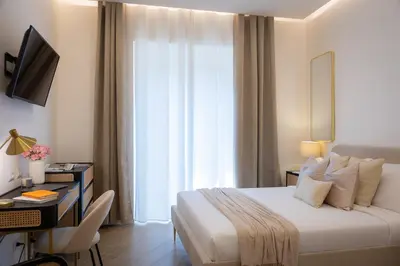 a hotel room with a bed and a desk and a television at Colosseum Boutique Apartment in Rome