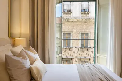 a bedroom with a bed and a large window at Colosseum Boutique Apartment in Rome