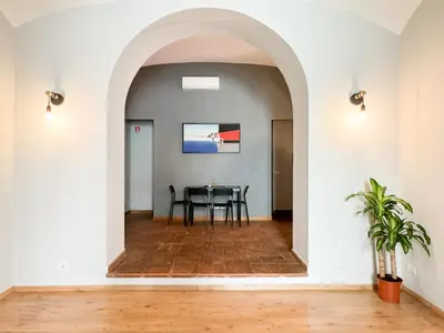 a dining room with an archway and a table at Tolemaide Boutique Apartment in Rome