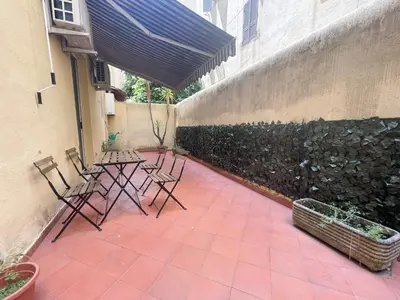 a patio with chairs and a table and a fence at Tolemaide Boutique Apartment in Rome
