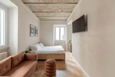a bedroom with a bed and a couch and a tv at iFlat Lovely Flat in Trastevere in Rome