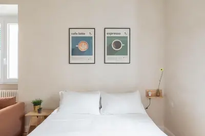 a bedroom with a white bed with three pictures on the wall at iFlat Lovely Flat in Trastevere in Rome