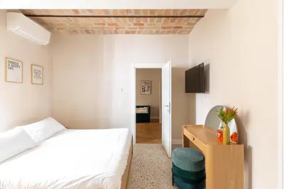 a bedroom with a bed and a desk and a tv at iFlat Lovely Flat in Trastevere in Rome
