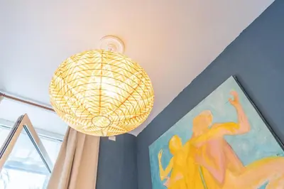 a pendant light in a room with a painting at Casa Benso - near Vatican City and Navona Square in Rome