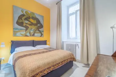 a bedroom with a bed with a painting on the wall at Casa Benso - near Vatican City and Navona Square in Rome
