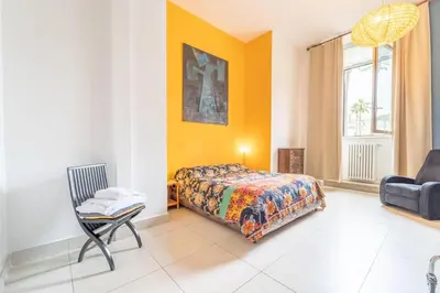 a bedroom with a bed and a chair and a window at Casa Benso - near Vatican City and Navona Square in Rome