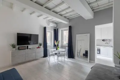 a white living room with a table and a kitchen at iFlat The G Flat in Rome