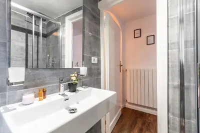 a bathroom with a white sink and a mirror at Piacentino Homes Corso apartment in Rome