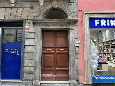 a building with a brown door in front of a store at Piacentino Homes Corso apartment in Rome