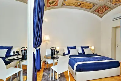 a bedroom with a bed and a table with chairs at AMM Luxury Rooms in Rome