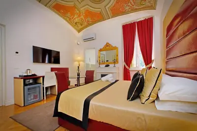 a bedroom with a large bed with red curtains at AMM Luxury Rooms in Rome