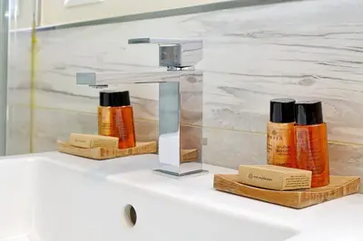 a bathroom sink with two bottles of essential oils at AMM Luxury Rooms in Rome
