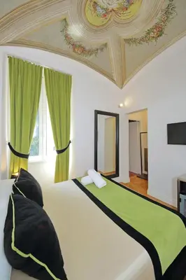 a bedroom with a large bed with green curtains at AMM Luxury Rooms in Rome