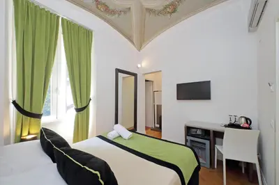a bedroom with a bed and a desk and a television at AMM Luxury Rooms in Rome