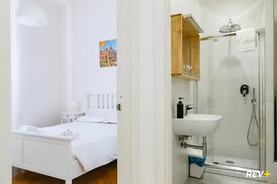 a bathroom with a bed and a sink and a shower at Mecenate Apartment Colosseum in Rome