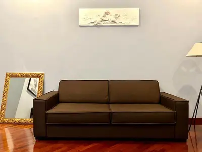 a brown couch in a living room with a mirror at Inn Sistina Home in Rome