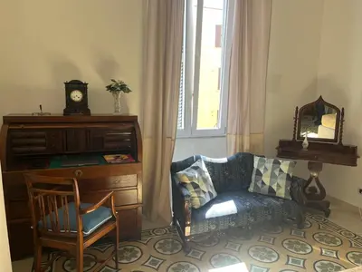 a living room with a chair and a dresser with a clock at Holiday Apartment Rome LR Blue in Rome