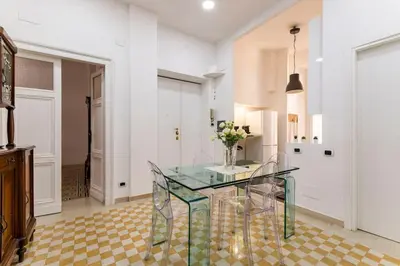 a dining room with a glass table with flowers on it at Holiday Apartment Rome LR Blue in Rome