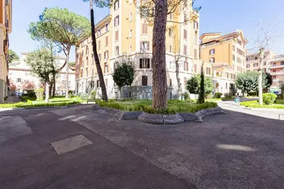 a parking lot with a tree in front of a building at The Great Beauty - 2 double bedrooms & 2 bathrooms in Rome