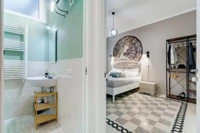 a bathroom with a sink and a bed in a room at The Great Beauty - 2 double bedrooms & 2 bathrooms in Rome