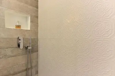 a shower stall in a bathroom with a wall at Paolina Boutique Apartment Monti in Rome