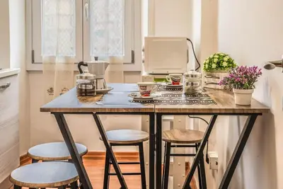 a kitchen island with two stools and a coffee maker at Giuliana St.Peter Apartment in Rome