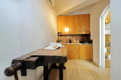 a kitchen with wooden cabinets and a wooden table at Fontanella Dream apartment in Rome
