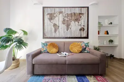 a brown couch in a living room with a map on the wall at Principe Umberto Apartment in Rome