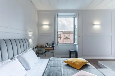 a bedroom with a large bed and a window at Rome Plaza Suites, Luxury Collection in Rome