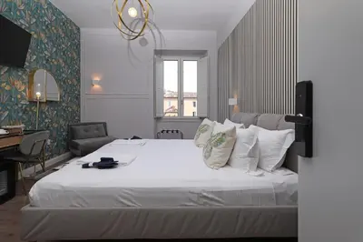 a bedroom with a large bed with white sheets and pillows at Rome Plaza Suites, Luxury Collection in Rome