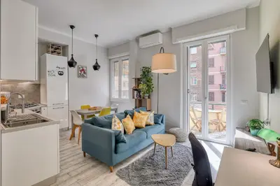 a living room with a blue couch and a kitchen at Re di Roma Apartment in Rome