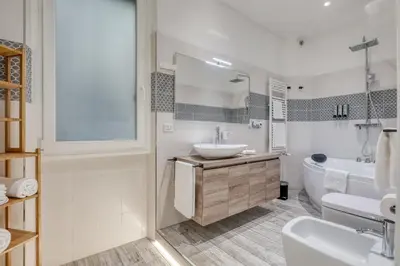 a white bathroom with a sink and a tub at Re di Roma Apartment in Rome
