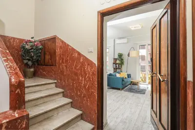 an open door to a living room with a potted plant at Re di Roma Apartment in Rome