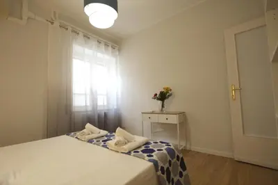 a bedroom with a bed and a window and a table at Vascello Holiday House in Rome