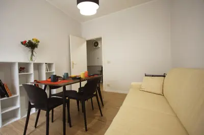 a living room with a table and chairs and a couch at Vascello Holiday House in Rome