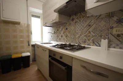 a kitchen with a stove top oven next to a window at Vascello Holiday House in Rome