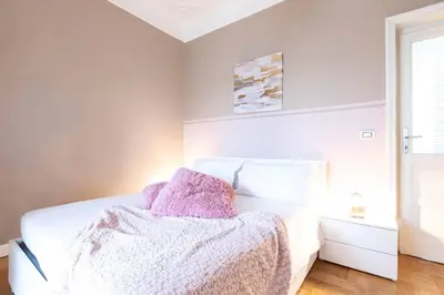 a bedroom with a white bed with a blanket on it at Colosseo Terrace Apartment in Rome