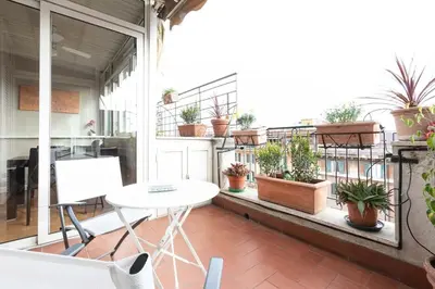 an apartment balcony with potted plants and a table at Colosseo Terrace Apartment in Rome