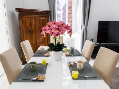 a dining room table with a vase of flowers on it at FCR Rome Apartments Gracchi Vatican in Rome