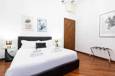 a bedroom with a large white bed with two tables at Amazing Art Déco Apartment Pantheon in Rome