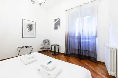 a white room with a table and a chair at Amazing Art Déco Apartment Pantheon in Rome