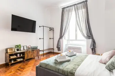a bedroom with a bed and a tv on the wall at Appartamento Principe Amedeo in Rome
