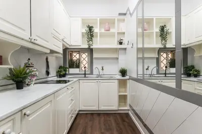 a large white kitchen with white cabinets and sinks at Appartamento Principe Amedeo in Rome