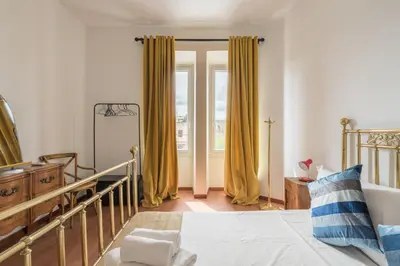 a bedroom with yellow curtains and a bed and a window at Stylish Pigneto Apartment in Rome