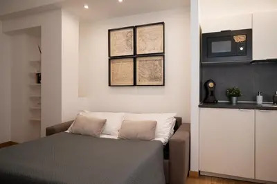 a small bedroom with a bed and a kitchen at Residenza Lualdi in Rome