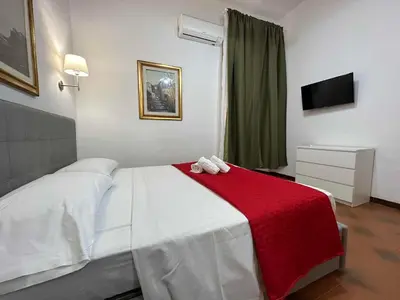 a bedroom with a white bed with a red blanket at Center Apartments vittorio Emanuele in Rome