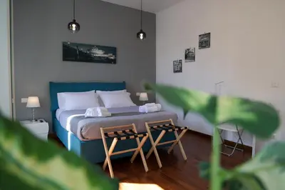 a bedroom with a blue bed with two tables at Pantheon Magic House in Rome