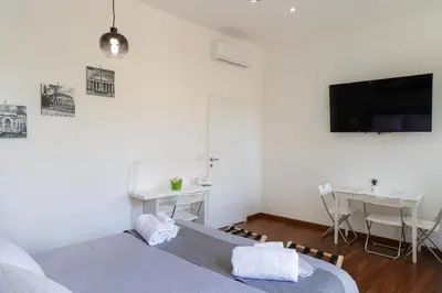 a bedroom with two beds and a desk and a tv at Pantheon Magic House in Rome